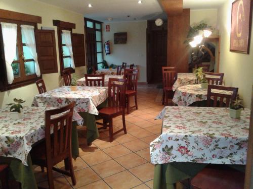 Camango罗伊洛瓦村庄旅馆的餐厅设有桌椅,并种有鲜花
