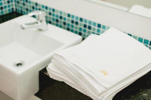 库里提巴阿拉丁酒店的浴室设有水槽上的2条白色毛巾