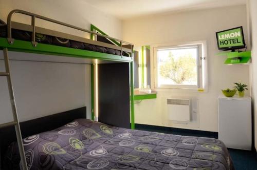 罗什福尔-迪加尔亚维农罗什福尔柠檬酒店的一间小卧室,配有双层床和窗户