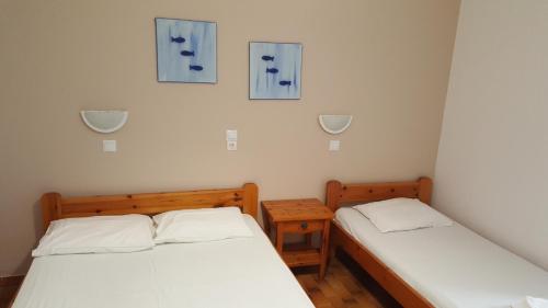帕罗奇亚Aratos Hotel的墙上挂着蓝色照片的客房内的两张床