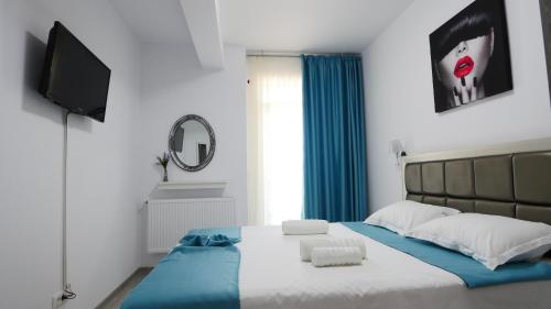 北马马亚-讷沃达里Sophia Apartment的一间卧室配有一张带蓝毯的床和一台电视