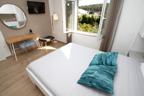 马卡尔斯卡Apartments Besker的一张白色的床,上面有蓝色的枕头