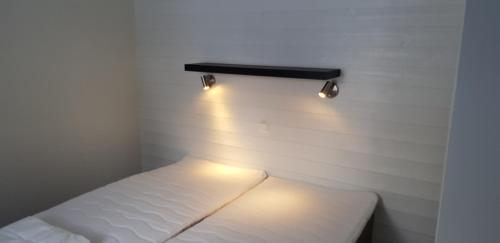 赖特维克Rättviks Golfby的小房间,墙上有一张带灯的床