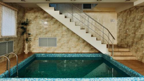 阿斯塔纳格德曼艾姆派尔酒店的一座带楼梯的游泳池和一个游泳池