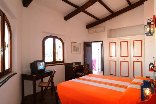 阿祖罗港卡拉迪莫拉公寓式酒店的一间卧室配有橙色的床和电视