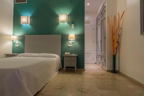 普韦布洛·纽沃·德·加德德拉戈旅馆的一间卧室设有一张床和绿色的墙壁