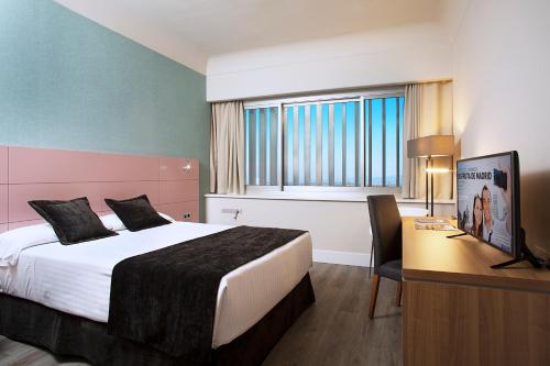 马德里Hotel Chamartin The One的酒店客房配有一张床和一张带电脑的书桌