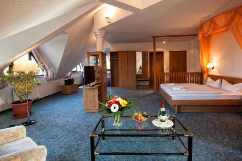 Lengefeld瓦尔德斯鲁酒店的配有床和鲜花桌的酒店客房