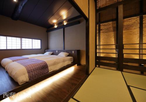 京都侯卡度假屋的一间卧室设有一张大床和一个窗户。