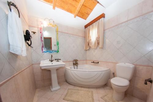 里科索翁SunRise Vila的浴室配有盥洗盆、卫生间和浴缸。