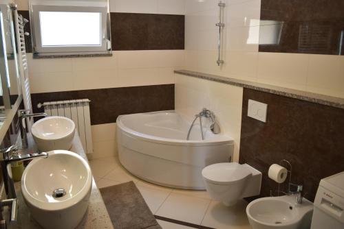 洛夫兰Apartment Antunovic的带浴缸、卫生间和盥洗盆的浴室