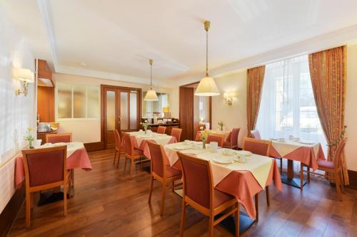 洛桑精英酒店的一间在房间内配有桌椅的餐厅
