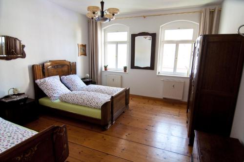 德累斯顿Kunsthofperle的一间卧室配有一张床、一张沙发和两个窗户。