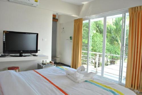 程逸府O.U.M. Hotel - โรงแรมโอยูเอ็ม的一间卧室设有一张带平面电视的床。