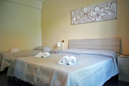 佩斯基耶拉德加达Lake moments的卧室内的两张床和拖鞋