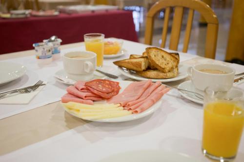 阿兰扎达布里萨酒店的一张桌子,上面放着一盘奶酪、面包和橙汁