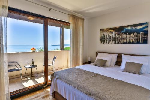 佩特罗瓦纳莫鲁Villa Rijeka Rezevici的一间卧室设有一张大床和一个大窗户