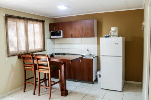 棕榈滩椰子酒店的厨房配有桌子和白色冰箱。