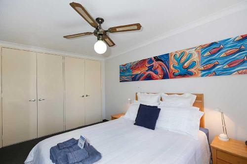 珀斯Beachfront @ Scarbs的卧室配有白色的床和吊扇