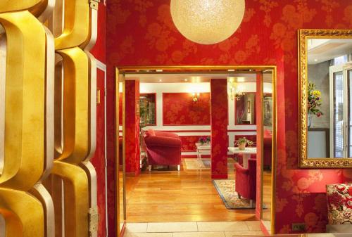 巴黎好男孩卢浮宫酒店的走廊上设有镜子和红色的墙壁