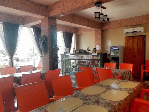 桑托斯将军城RSG微酒店的用餐室配有桌子、橙色椅子和桌椅