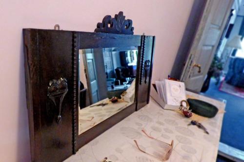 雷谢尔Apartamenty w Kamienicy的镜子坐在房间的床上