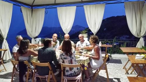 利帕里B&B Villa Maristella的一群坐在餐桌旁吃饭的人