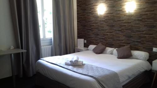 欧里亚克Le Relax的卧室配有白色的砖墙床