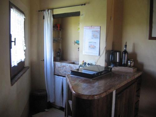 蒙特普齐亚诺S. Bartolomeo II° - "La Loggetta"的厨房配有带水槽的柜台和窗户。