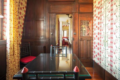 鲁昂La Maison Des Vieux Logis的用餐室配有桌子和带窗帘的墙壁