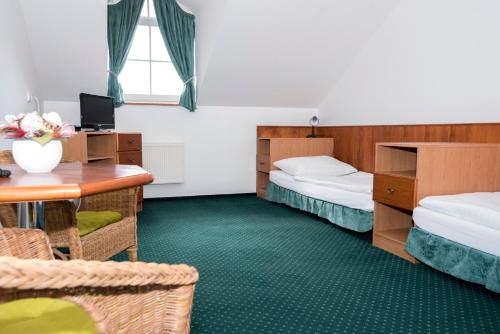 什捷季潘哉恩欧阿泽酒店的客房设有两张床、一张桌子和一张桌子。