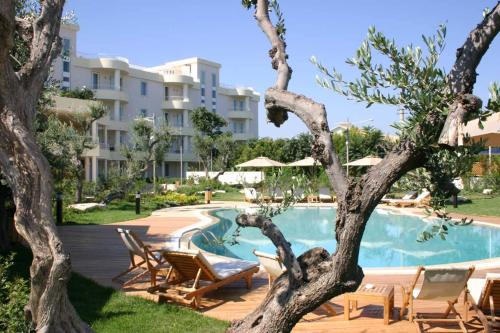 焦维纳佐巴里焦维纳佐宜必思尚品酒店的一个带游泳池和椅子的度假胜地和一座建筑