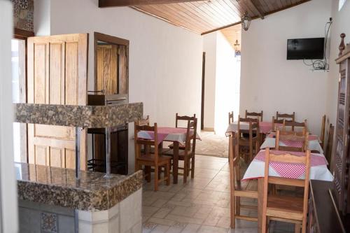 蒂拉登特斯Pousada Sinhá Vilaça的一间带桌椅和壁炉的餐厅