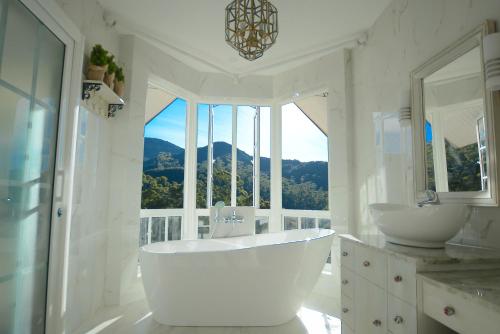 努沃勒埃利耶豪华野外别墅的白色浴室设有两个盥洗盆和大窗户。