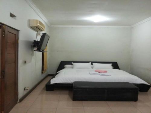 万隆Seventeen homestay的卧室配有一张床,墙上配有电视。