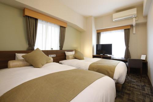 横滨Rembrandt Style Yokohama Kannai的酒店客房设有两张床和一台平面电视。