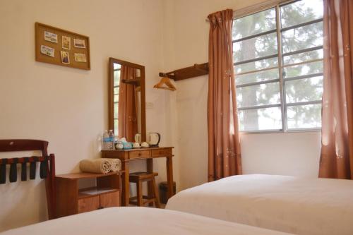 昆达桑昆达山斯盖威尔禅意度假村的一间卧室设有两张床和窗户。