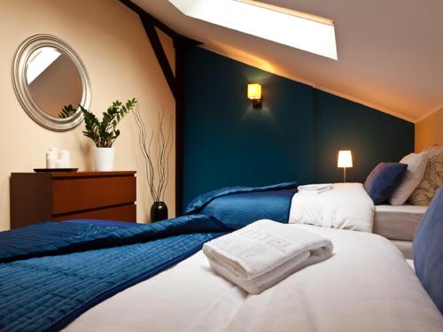波兹南花卉公寓旅馆的一间卧室配有两张床和镜子