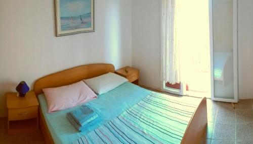 卢卡瓦克Apartman Knezevic的小卧室配有一张带蓝色毯子的床