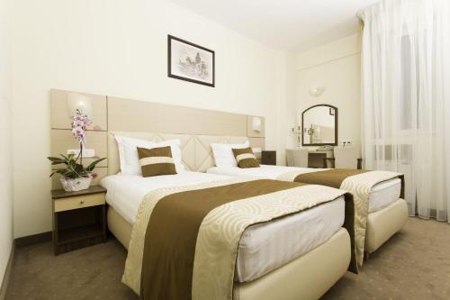 比斯特里察Grand Hotel Coroana的酒店客房,设有两张床和镜子