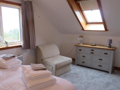 斯托诺韦Orasaidh Apartment的一间卧室配有一张床、一把椅子和镜子