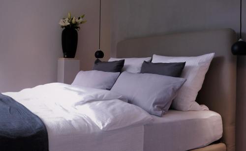 坡瑟利特兹Die Hütten Appartements的一张白色的床,上面有一堆枕头