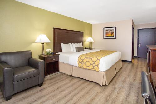 凤凰城51号大街贝蒙特旅馆套房酒店的配有一张床和一把椅子的酒店客房