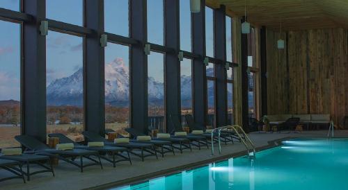 百内三塔里奥塞拉诺酒店及Spa的一座带椅子的游泳池和一座山地