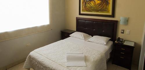皮乌拉Rivera del Rio Hotel的一间卧室配有一张床,上面有两条毛巾