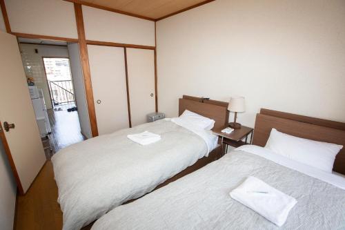 冈山Lazy House的小型客房配有两张床,