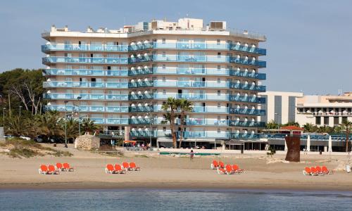 拉皮内达多内尔海滩黄金酒店的海滩上一座大型建筑,配有椅子和人