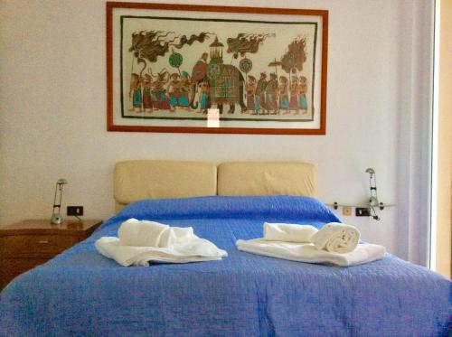 阿巴迪亚拉里亚纳La Meridiana sul Lago的一间卧室配有蓝色的床和毛巾