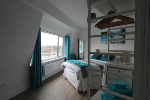 利物浦2 Serviced Apartments in Childwall-South Liverpool - Each Apartment Sleeps 6的一间卧室配有双层床和窗户。
