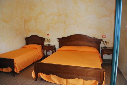 伦德Agriturismo La Turritella的配有橙色床单的客房内的两张床